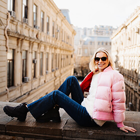 Женщина сидит на исторической стене в Ичеришехер, Старый город Баку, во время уличной фотосессии