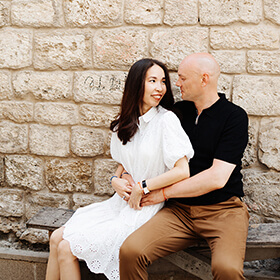 Couple sitting together against a historic stone wall during a walking photography tour in Baku Old Town, Azerbaijan.